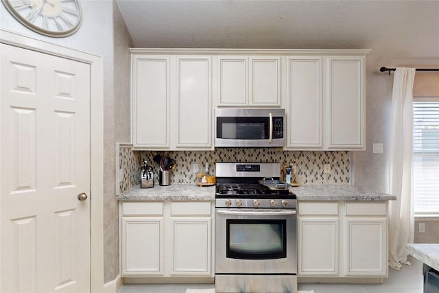 13931 Pueblo Run, Cypress, TX 77429 - kitchen with stainless steel appliances, tasteful backsplash, and white cabinetry