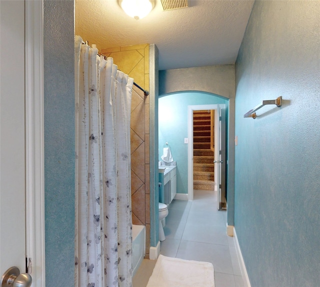 13931 Pueblo Run, Cypress, TX 77429 - full bathroom with tile patterned flooring, shower / tub combo with curtain, baseboards, a textured ceiling, and toilet