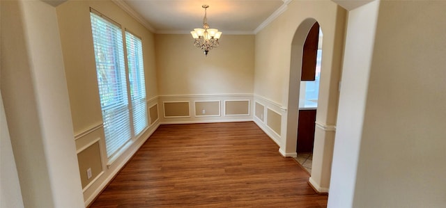 23823 Wispy Way, Katy, TX 77494 - spare room with arched walkways, crown molding, a chandelier, wood finished floors, and a decorative wall