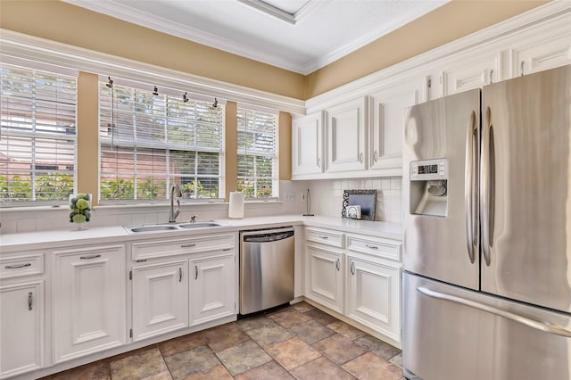 kitchen with appliances with stainless steel finishes, a sink, white cabinetry, and ornamental molding
