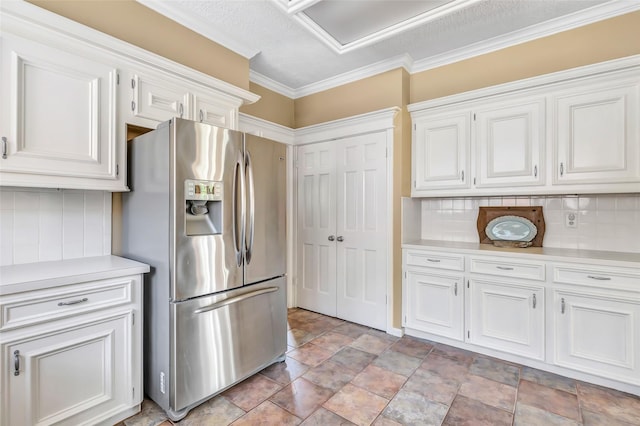 kitchen with stainless steel fridge with ice dispenser, light countertops, white cabinets, backsplash, and stone finish flooring