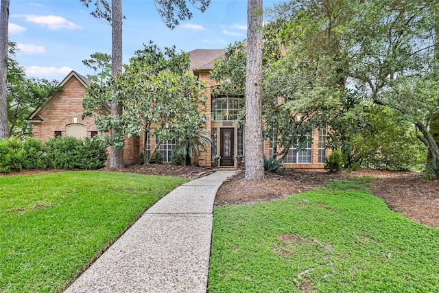 view of front of home with brick siding and a front lawn
