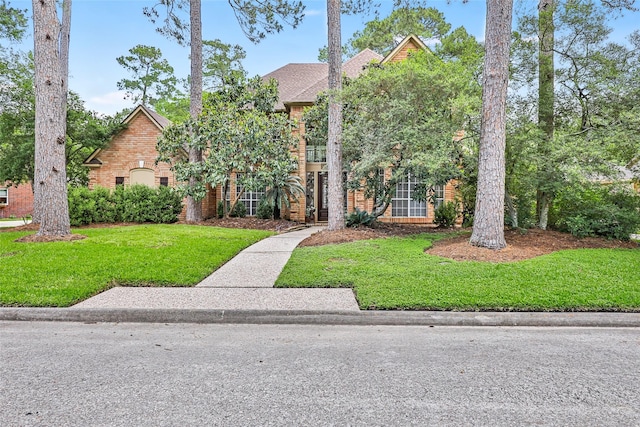 view of front of home with brick siding and a front yard