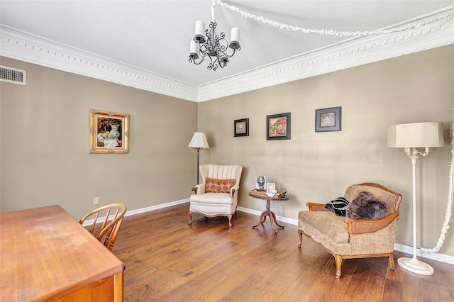 sitting room with ornamental molding, a chandelier, wood finished floors, and baseboards