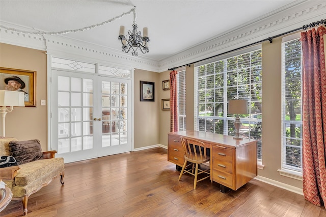 office space with a chandelier, healthy amount of natural light, wood finished floors, crown molding, and baseboards