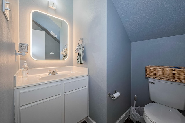 half bathroom featuring toilet, vanity, vaulted ceiling, and a textured ceiling