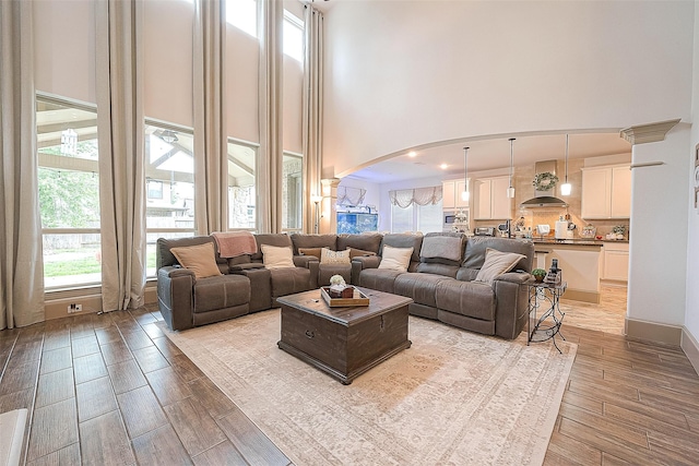 3911 Avalon Ridge Dr, Spring, TX 77386 - living area featuring arched walkways, a towering ceiling, and light wood-type flooring