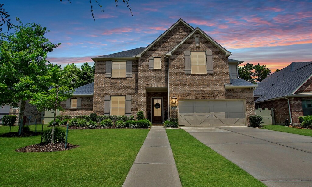 9975 Preserve Way, Conroe, TX 77385 - traditional home with concrete driveway, brick siding, an attached garage, and a front yard