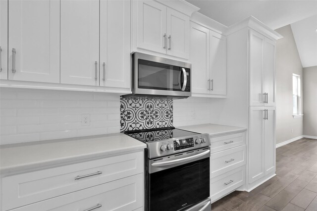 20900 Welch Rd, Richards, TX 77873 - kitchen with stainless steel appliances, light countertops, white cabinetry, and decorative backsplash