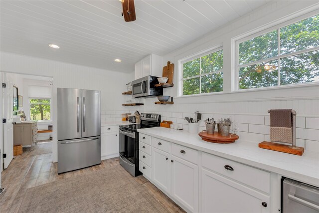 6020 State Highway 159, La Grange, TX 78945 - kitchen featuring appliances with stainless steel finishes, open shelves, tasteful backsplash, white cabinets, and light wood-style floors