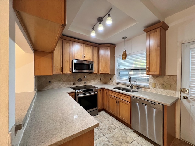 2930 Grants Lake Blvd Unit 2404, Sugar Land, TX 77479 - kitchen with stainless steel appliances, a tray ceiling, a sink, light countertops, and brown cabinets