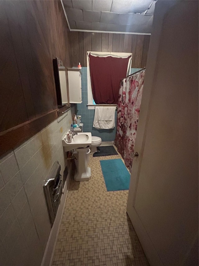 3439 5th St, Port Arthur, TX 77642 - full bathroom featuring toilet, tile patterned floors, curtained shower, wood walls, and a sink