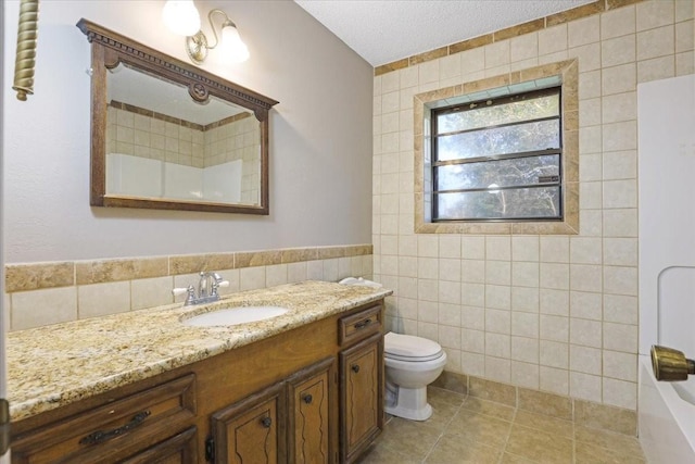 13519 Montgomery Rd, Santa Fe, TX 77510 - full bathroom featuring tile walls, toilet, vanity, and tile patterned floors