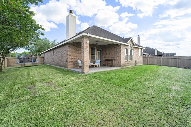 12019 Eagle Ridge Dr, Dayton, TX 77535 - back of property featuring a chimney, a trampoline, a ceiling fan, brick siding, and a patio area