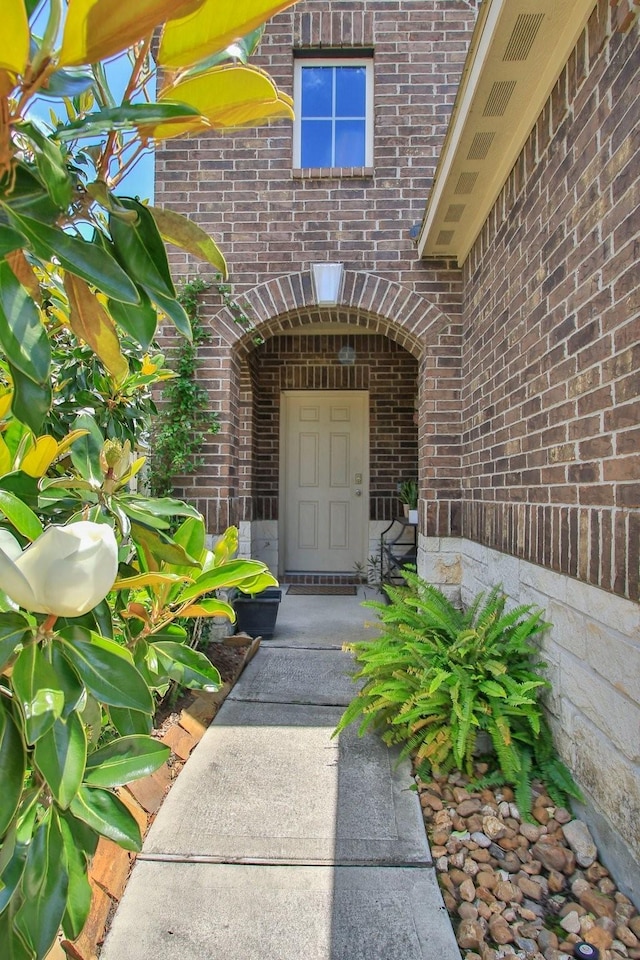property entrance featuring brick siding