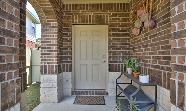view of exterior entry featuring brick siding