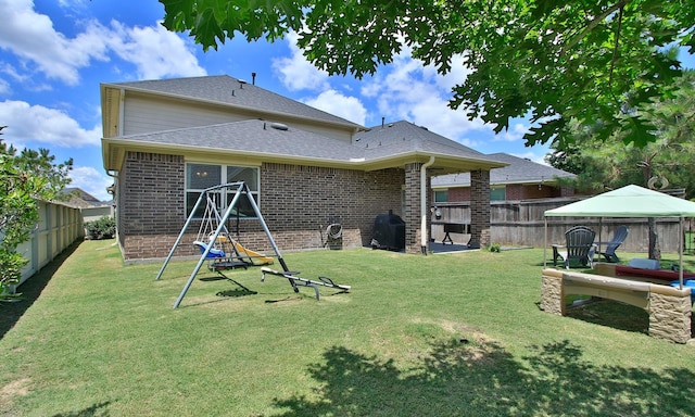 back of property featuring brick siding, a gazebo, and roof with shingles