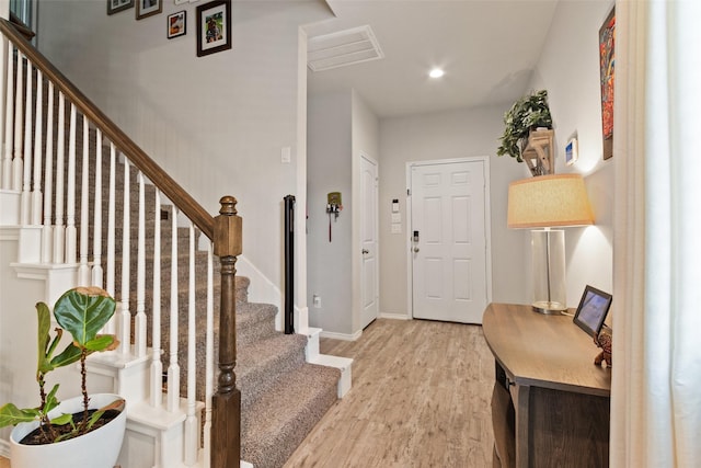 entrance foyer with light wood-style floors, stairs, baseboards, and recessed lighting