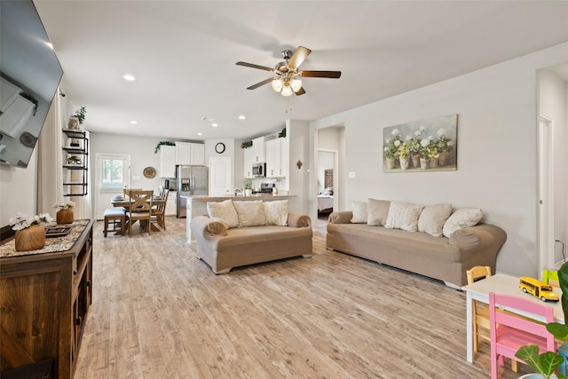 living area featuring light wood-type flooring, ceiling fan, and recessed lighting