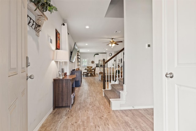 foyer with light wood finished floors, a ceiling fan, baseboards, recessed lighting, and stairs