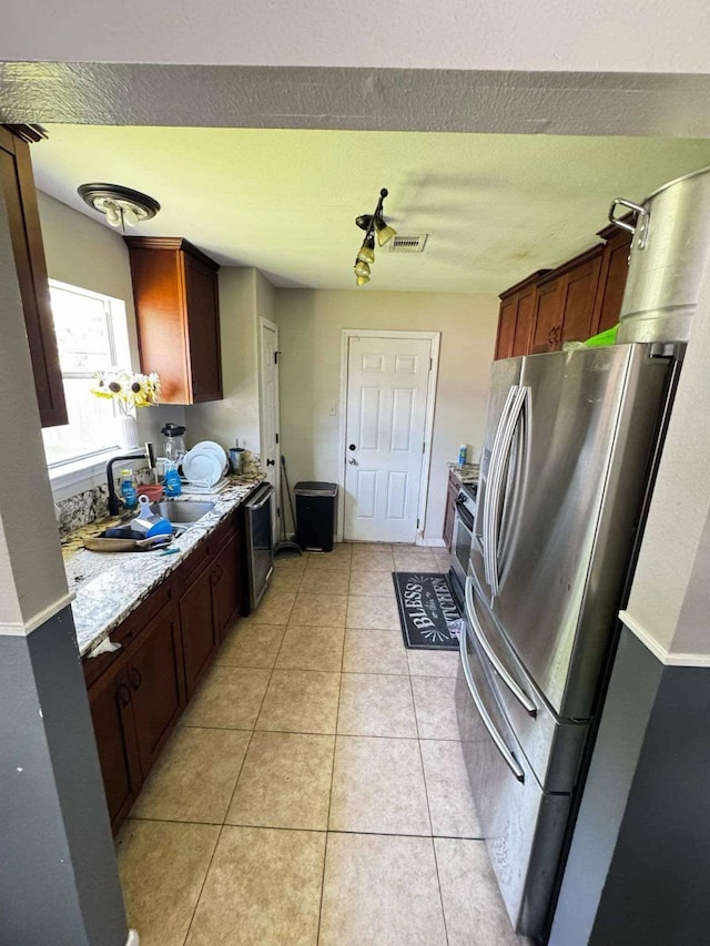 8206 Claiborne St, Houston, TX 77078 - kitchen with freestanding refrigerator, a sink, dishwasher, and light tile patterned floors