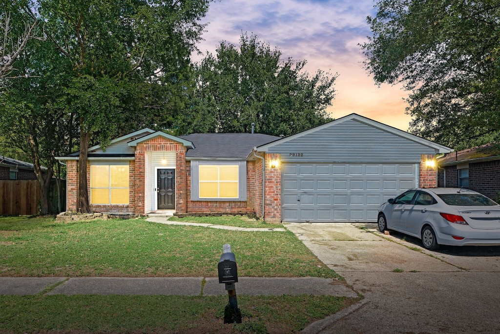 ranch-style house with driveway, an attached garage, and brick siding