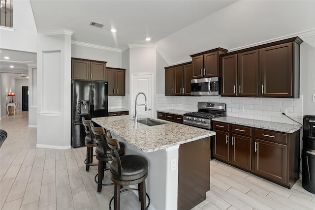 19011 Whistling Duck Dr, Cypress, TX 77433 - kitchen featuring stainless steel appliances, a sink, decorative backsplash, dark brown cabinets, and light stone countertops