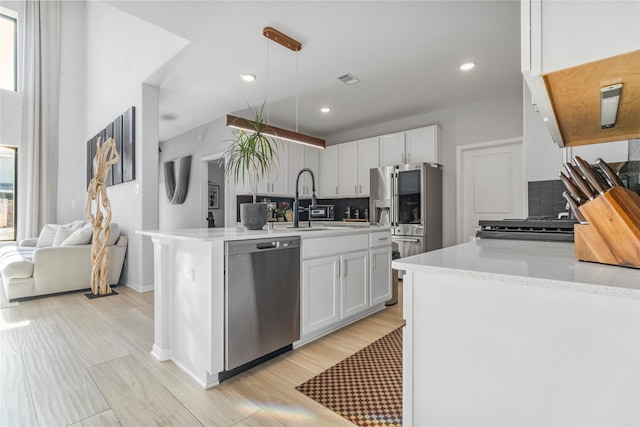 8811 Sandhill Crane Rd, Baytown, TX 77521 - kitchen featuring stainless steel dishwasher, decorative backsplash, white cabinetry, hanging light fixtures, and recessed lighting