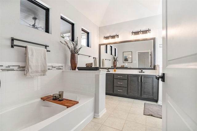 8811 Sandhill Crane Rd, Baytown, TX 77521 - bathroom featuring tile patterned flooring, a garden tub, vanity, and vaulted ceiling
