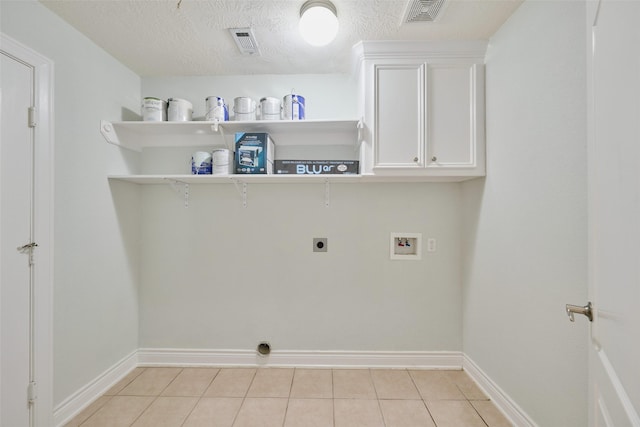 13313 Enchanted Way Dr, Montgomery, TX 77356 - laundry room with hookup for a washing machine, hookup for an electric dryer, baseboards, light tile patterned flooring, and cabinet space