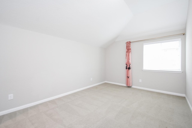 bonus room with lofted ceiling, light colored carpet, and baseboards