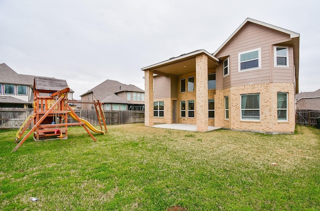 rear view of property with a playground, a patio area, and brick siding