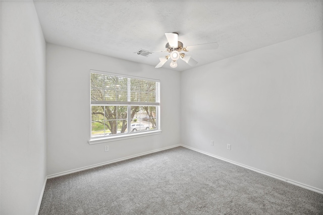 carpeted empty room with a ceiling fan and baseboards