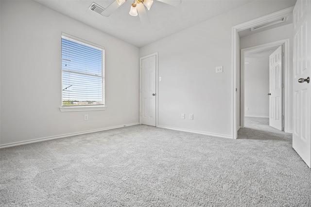 carpeted empty room with a ceiling fan and baseboards