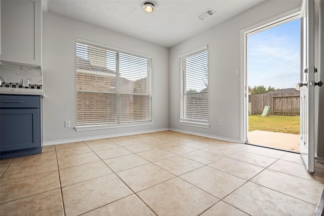 unfurnished dining area featuring light tile patterned floors and baseboards