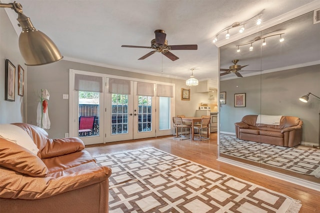 living area featuring a ceiling fan, wood finished floors, ornamental molding, and french doors