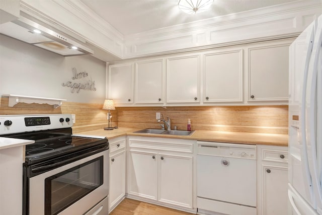 kitchen featuring white appliances, a sink, light countertops, premium range hood, and crown molding