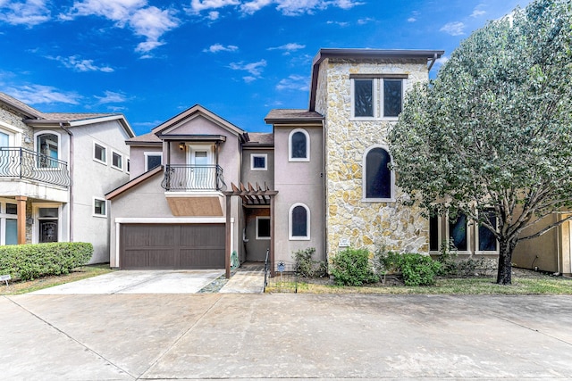 11022 Robin Hood Ct, Houston, TX 77043 - view of front of house featuring a balcony, concrete driveway, stone siding, an attached garage, and stucco siding