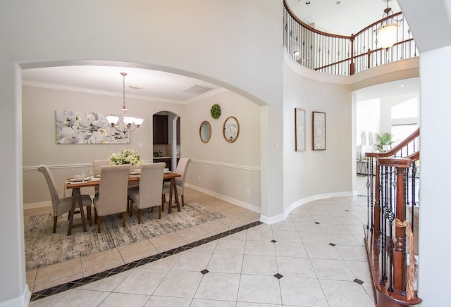 5530 Riverstone Crossing Dr, Sugar Land, TX 77479 - dining area featuring tile patterned flooring, crown molding, arched walkways, a chandelier, and baseboards