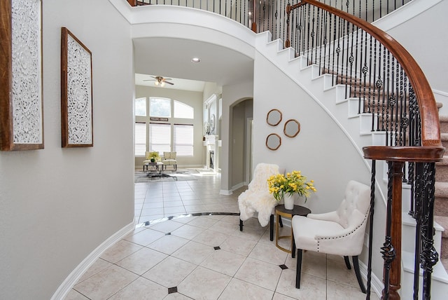 5530 Riverstone Crossing Dr, Sugar Land, TX 77479 - entrance foyer with arched walkways, light tile patterned floors, ceiling fan, baseboards, and stairs