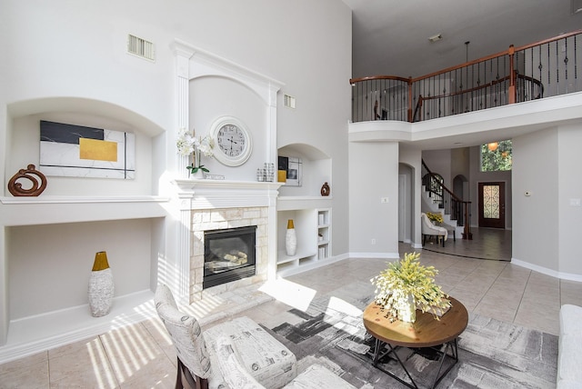 5530 Riverstone Crossing Dr, Sugar Land, TX 77479 - living room with built in shelves, stairway, a stone fireplace, arched walkways, and a high ceiling