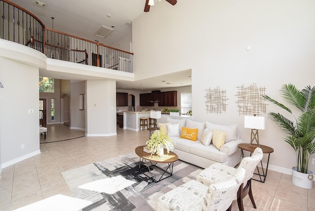 5530 Riverstone Crossing Dr, Sugar Land, TX 77479 - living area with light tile patterned floors, a ceiling fan, baseboards, a towering ceiling, and arched walkways