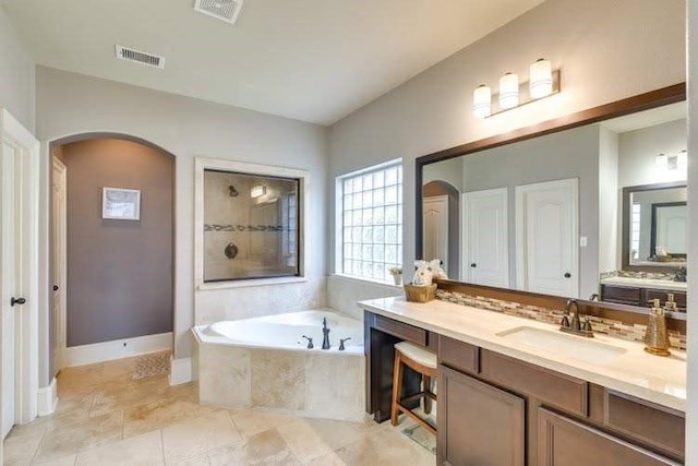 full bathroom featuring a bath, tiled shower, vanity, and tile patterned flooring