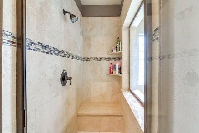 bathroom featuring a tile shower and plenty of natural light