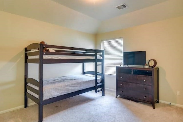 bedroom featuring light colored carpet, baseboards, and vaulted ceiling
