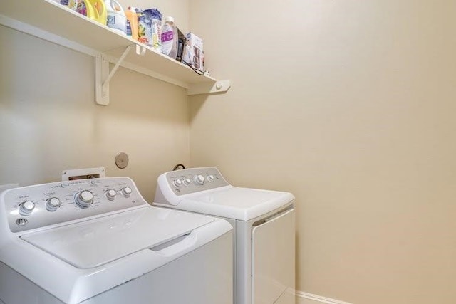 washroom with washer and clothes dryer and baseboards