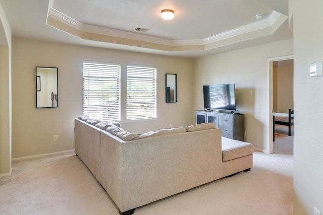 living area with ornamental molding, a tray ceiling, light colored carpet, and baseboards
