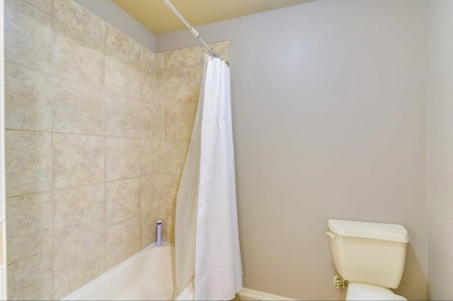 full bath with toilet, shower / bath combination with curtain, and baseboards