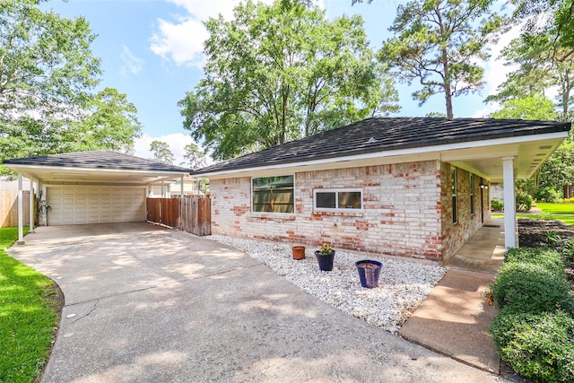 view of side of property featuring fence, brick siding, and a detached garage