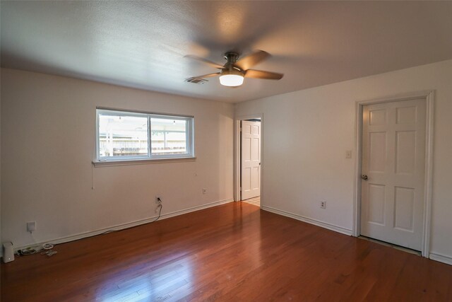 unfurnished bedroom featuring wood finished floors, baseboards, and a ceiling fan